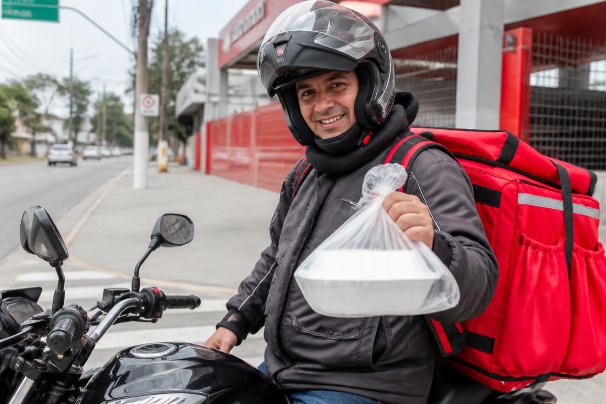 Motoboy entregando marmita fechada do JD Paladar em Betim